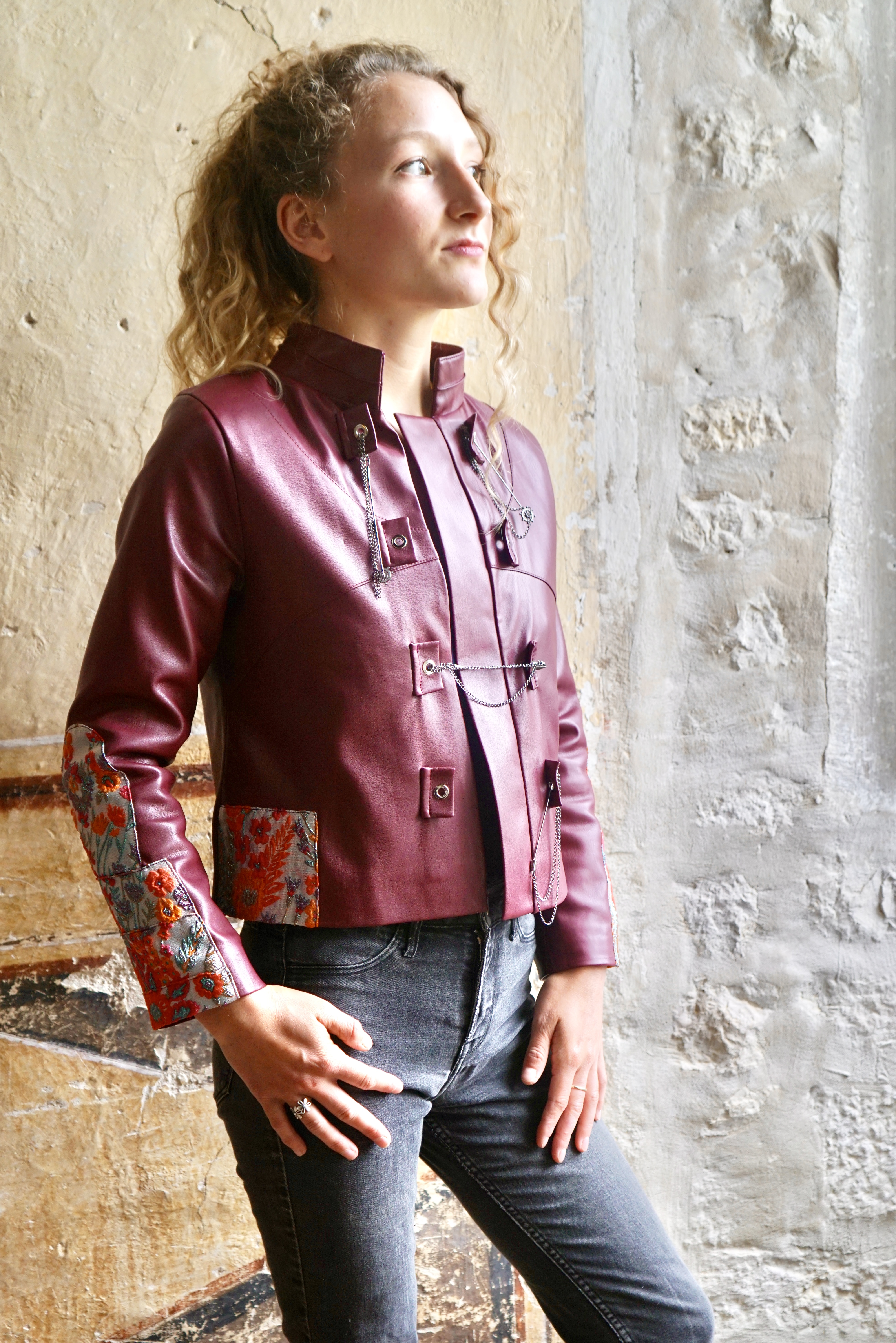 Gros plan sur une veste en cuir rouge avec des fermoirs métalliques sur le devant